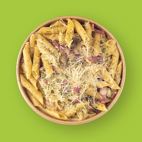 Penne carbonara met spekjes en geraspte kaas in een kraft bowl